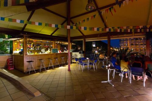 a restaurant with a bar and tables and chairs at Camping Bungalows El Far in Calella