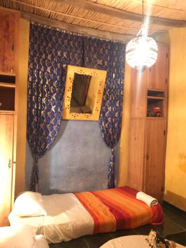 a bedroom with a bed and a picture on the wall at Auberge Chez Julia in Merzouga