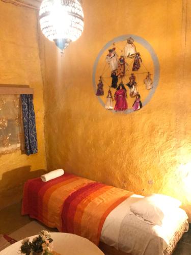 a bedroom with a bed with a colorful blanket at Auberge Chez Julia in Merzouga