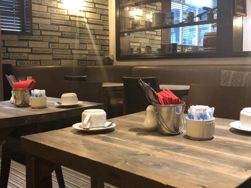 a wooden table in a restaurant with two tables with chairs at The Embassy Hotel in Hull