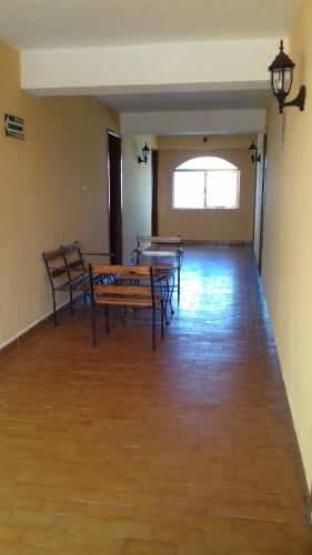 a room with tables and benches in a building at Hotel Progreso in Progreso