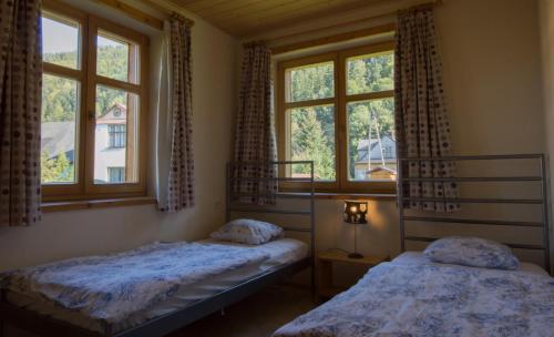 two beds in a room with two windows at Sno House in Szczyrk