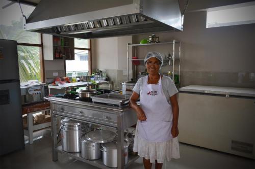 a woman is standing in a kitchen at Manu Gallito de las Rocas in Pillcopata