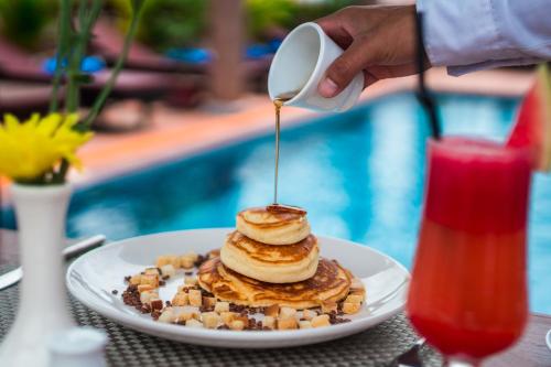 a person drizzling syrup on a plate of pancakes at Hello Cambodia Boutique in Siem Reap
