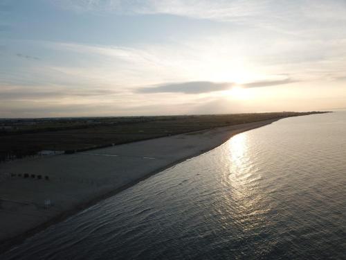 a beach with the sun setting over the water at b&b Tosches in Barletta