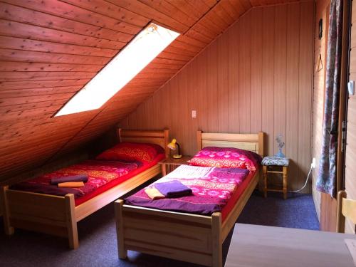 een slaapkamer met 2 bedden op een zolder bij Guest House U Náhonu in Chrudim