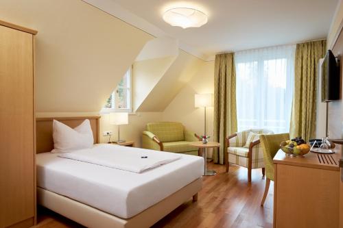 バート・ベリンゲンにあるFlair Hotel Schwanenのベッド、テーブル、椅子が備わるホテルルームです。