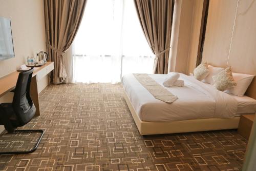 een hotelkamer met een bed en een groot raam bij Top Holiday Hotel in Seri Kembangan