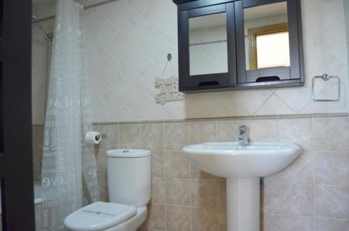 a bathroom with a sink and a toilet and a mirror at Terrasol Baviera Golf in Caleta De Velez