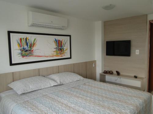 um quarto com uma cama e uma TV de tela plana em Flat Jampa Cobertura Duplex A Beira Mar em João Pessoa