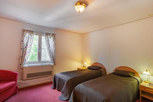 - 2 lits dans une chambre avec une fenêtre et un canapé dans l'établissement Swedish Village Hotel, à Timachiovsk