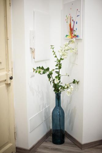a blue vase with flowers in it on a table at The Roman Way San Giovanni in Rome