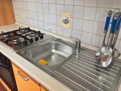 - un évier en acier inoxydable dans une cuisine à côté d'une cuisinière dans l'établissement SediciBis, à Bologne