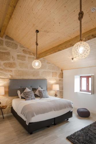 a bedroom with a large bed and two lights at Porto Deluxe Suites in Porto