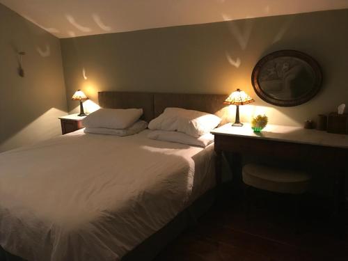 a bedroom with a large white bed with two lamps at Pleck Barn B&B in Ansty