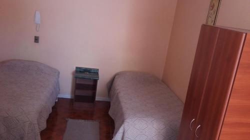 a bedroom with two beds and a dresser in it at Hotel Don Alfredo in Calama
