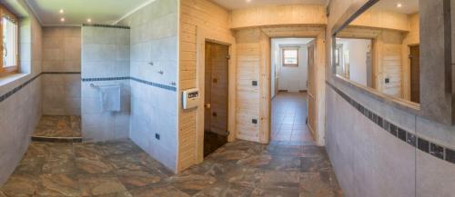 a bathroom with a walk in shower and a hallway at Sno Apartments in Szczyrk