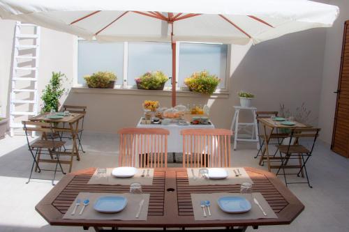 een eetkamer met een tafel en stoelen en een parasol bij B&B Radici in Trani