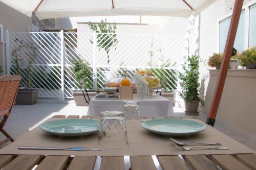 een tafel met borden en keukengerei op een patio bij B&B Radici in Trani