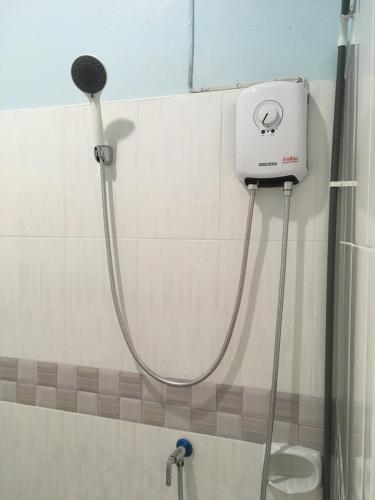 a shower with a hose attached to a wall at Khaosok Secret Hostel in Khao Sok National Park