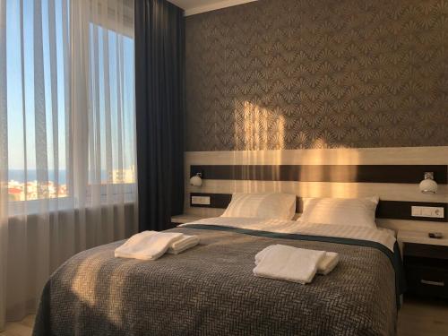 a bedroom with a large bed with two towels on it at The Rooms Apart in Odesa
