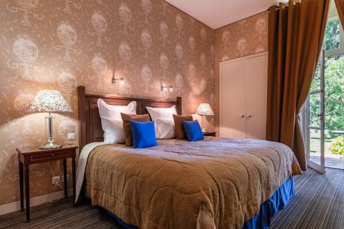 a bedroom with a large bed with blue pillows at La Chapelle Saint Martin in Nieul