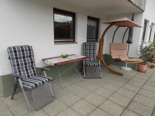 two chairs and a table on a patio at Ferienwohnung Dimpfl-Stad´l Fam. Lemberger in Lohberg