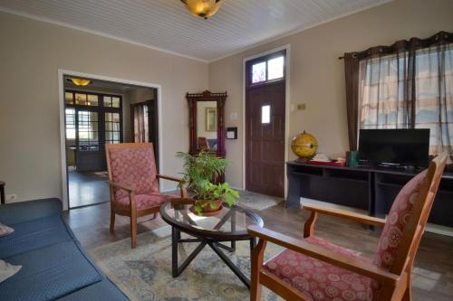 a living room with a table and chairs at Pista Q hostel and apartments in Oranjestad