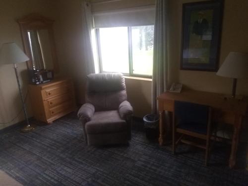 a room with a chair and a desk and a window at Super 8 by Wyndham Baxter/Brainerd Area in Baxter