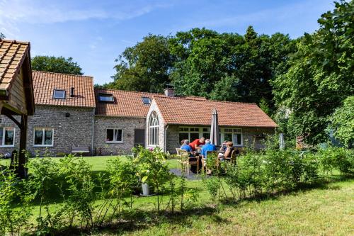 a group of people sitting in front of a house at B&B 't Heirweggoed in Assenede