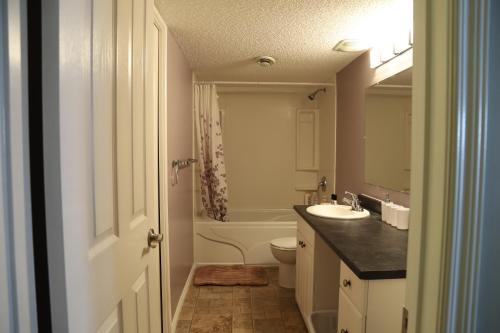 a bathroom with a sink and a toilet and a tub at Sweet Home In Calgary in Calgary