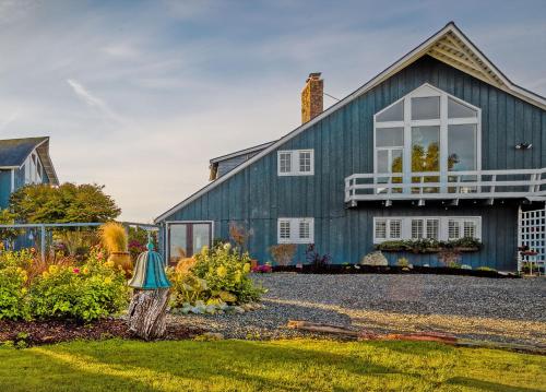 a blue house with a white window and a yard at Dungeness Barn House Bed and Breakfast at Two Crows Farm in Sequim