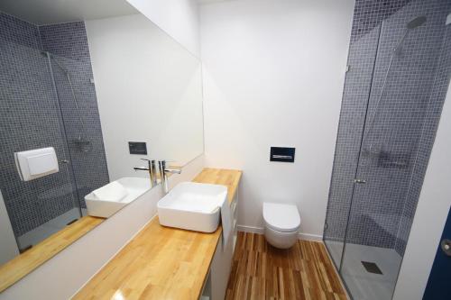 een badkamer met een wastafel, een toilet en een douche bij Casa de Santa Marta in Lissabon