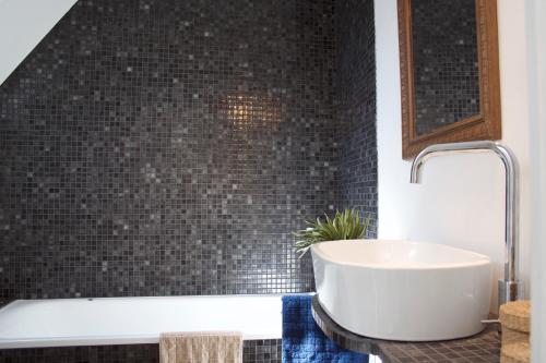 a bathroom with a sink and a bath tub at La Petite Maison d'à Côté in Saint-Aignan