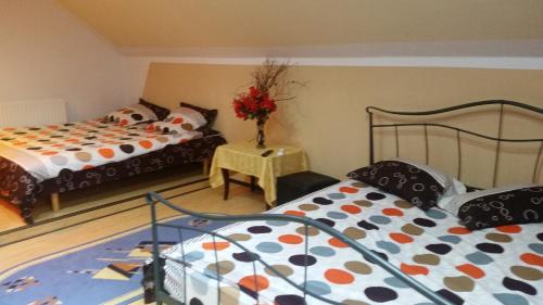 a bedroom with two beds and a table with a vase of flowers at Cabana Steaua Nordului 2 in Vînători