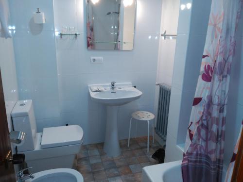 La salle de bains blanche est pourvue d'un lavabo et de toilettes. dans l'établissement Hotel Vaqueros, à Langreo