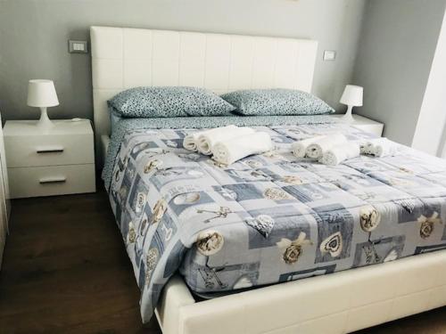 a bedroom with a bed with a blue and white blanket at Marina Apartment & suite in Verbania