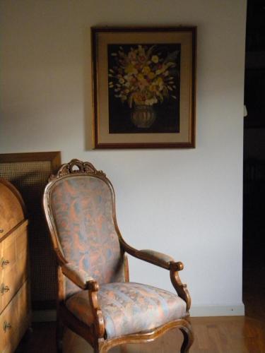 an old chair sitting in a room with a painting at Agriturismo Tenuta il Tasso in Rapolano Terme