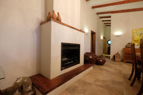 a living room with a fireplace in a house at Thatch by the Sea in Blythedale