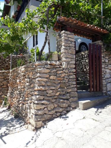 a stone wall with a gate in front of a building at Apartman SB in Ulcinj