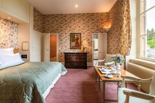 a bedroom with a bed and a desk and a table at La Chapelle Saint Martin in Nieul