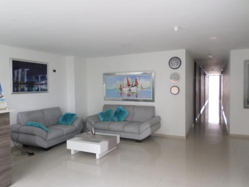 uma sala de estar com dois sofás e uma mesa em Hotel Suites Caribe em Barranquilla