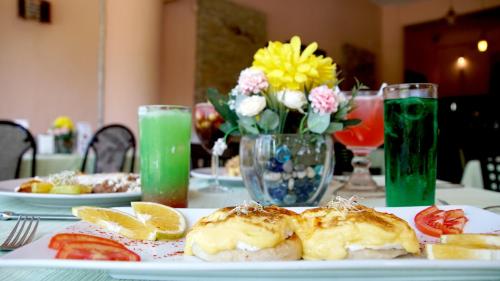 a table with a plate of food and flowers and drinks at Hotel Costa Brava in Manzanillo