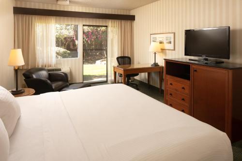 a hotel room with a bed and a flat screen tv at Red Lion Hotel Bellevue in Bellevue