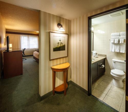 a bathroom with a toilet and a sink and a stool at Red Lion Hotel Bellevue in Bellevue