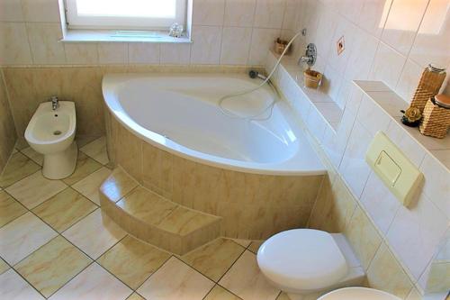 y baño con bañera, aseo y lavamanos. en Exclusive Apartments, en Bietigheim-Bissingen