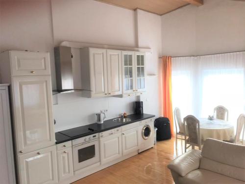 una cocina con armarios blancos y fregadero en Exclusive Apartments, en Bietigheim-Bissingen
