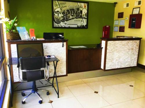 a waiting room with a desk and a chair at Super 8 by Wyndham Brunswick/St Simons Island Area in Brunswick