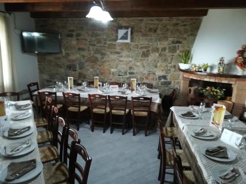 une salle à manger avec des tables et des chaises et un mur en pierre dans l'établissement Agriturismo la vallata, à Masseria Scilva