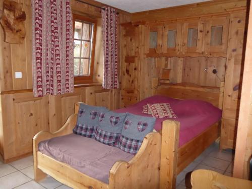 a bedroom with a bed in a log cabin at Chalet Les Liouès in Sollières-Sardières